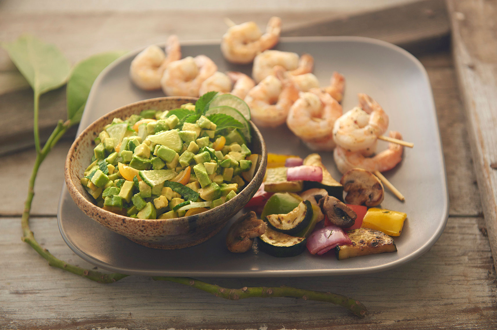 Beautiful-food-photography-of-grilled-shrimp-skewers-and-summer-vegetables-with-mint-lime-avocado-relish