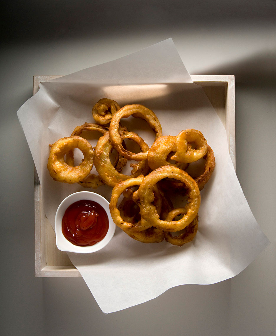 Beautiful-food-photography-of-onion-rings-on-parchment-with-ketchup-side
