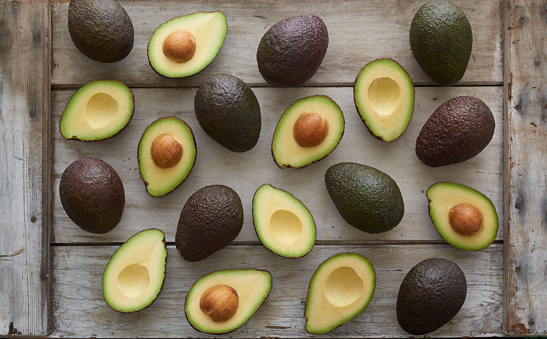 Whole-and-cut-in-half-California-grown-hass-avocados-white-barn-wood-by-Joe-Atlas-food-photography.