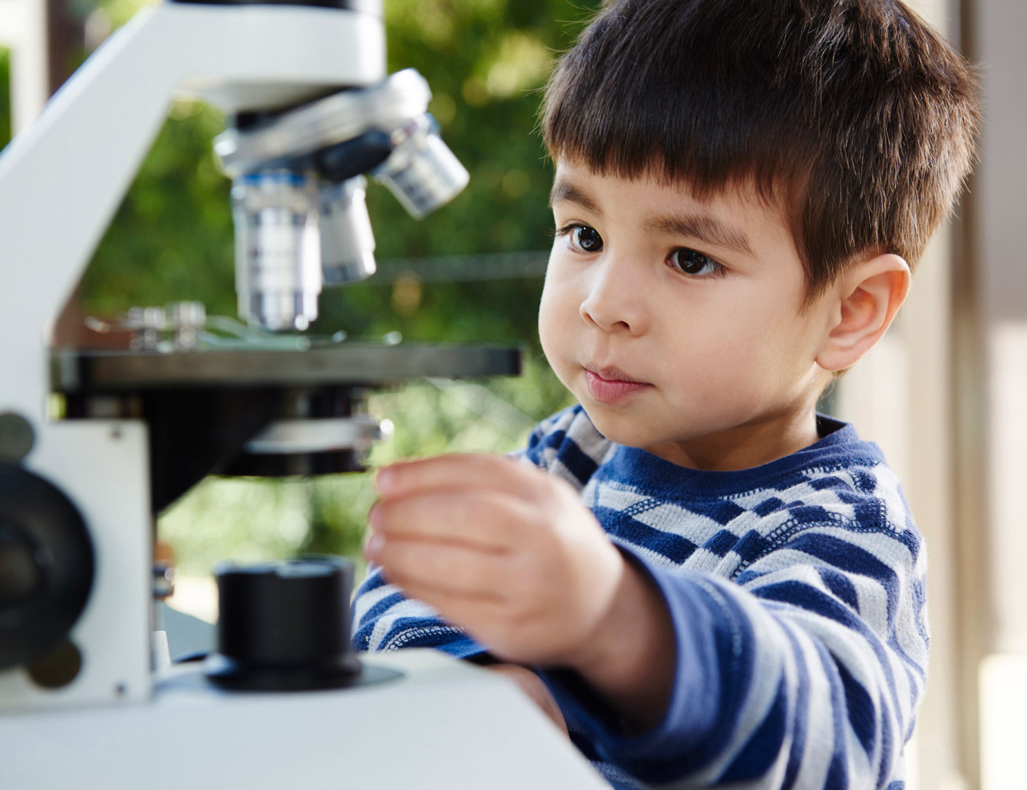 Young-boy-adjusting-microscope-by-annual-report-photographer-Joe-Atlas..